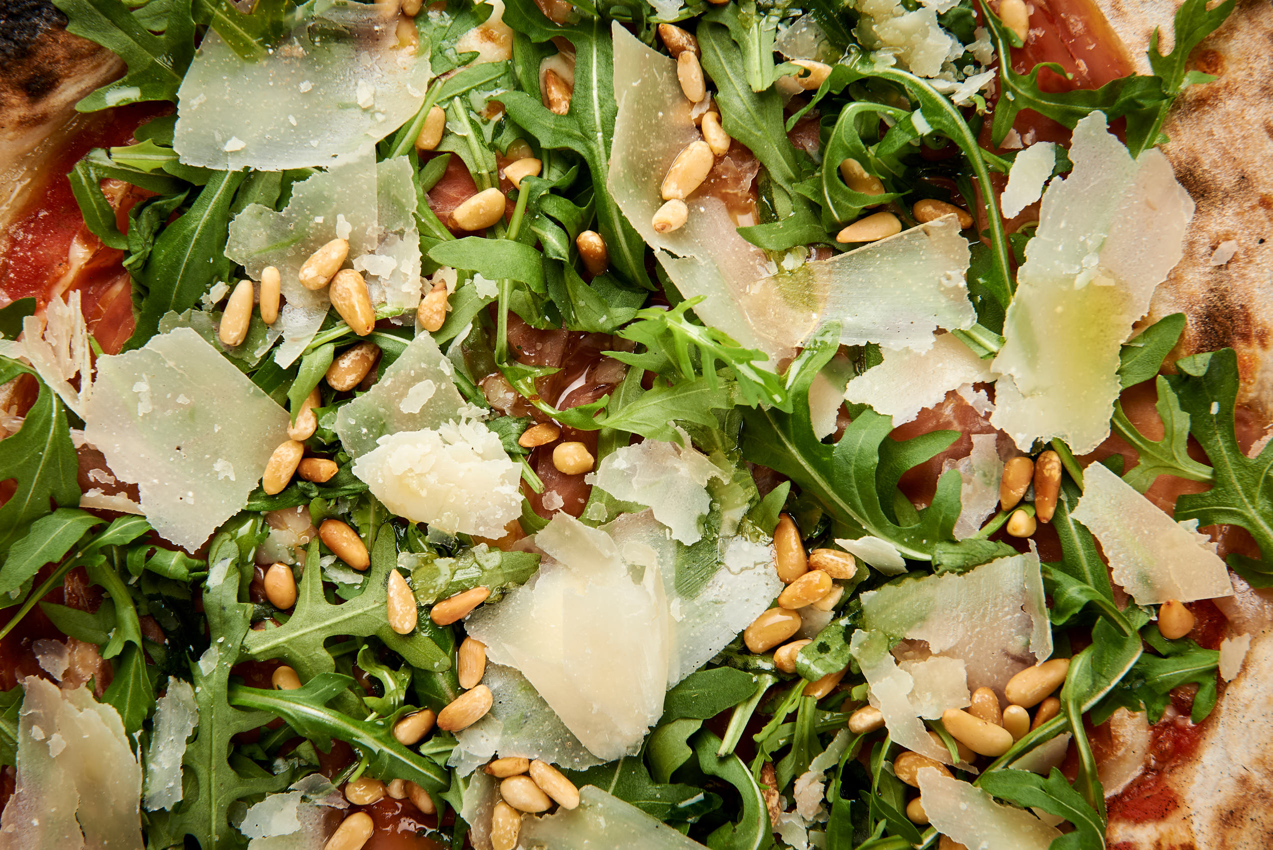 Parmapizza with pine nuts closeup photo by Marcel Tiedje